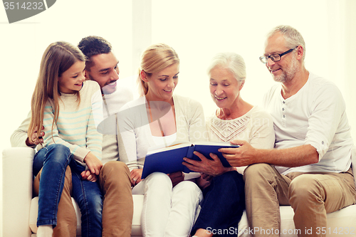 Image of happy family with book or photo album at home