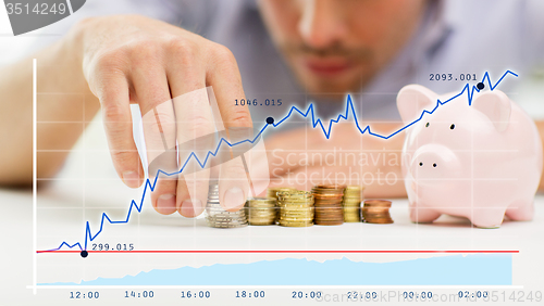 Image of close up of businessman with piggy bank and coins
