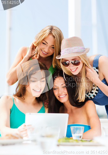 Image of girls looking at tablet pc in cafe