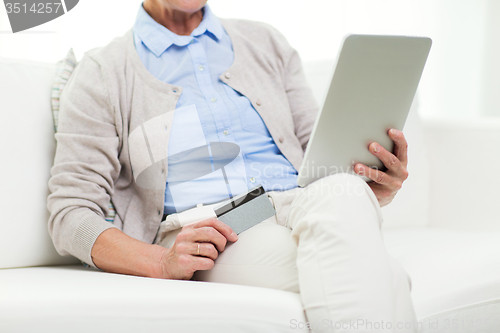 Image of senior woman with tablet pc and credit card