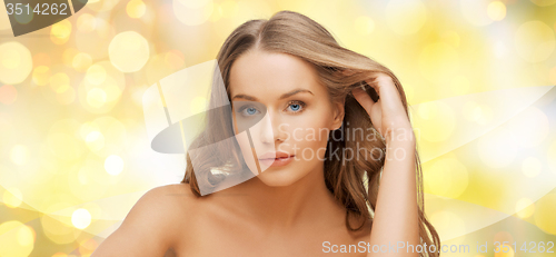 Image of beautiful young woman face over yellow lights