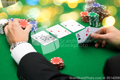 Image of poker player with cards and chips at casino