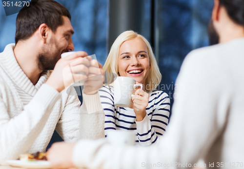 Image of happy friends meeting and drinking tea or coffee