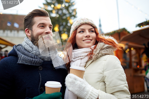 Image of happy couple drinking coffee on old town street