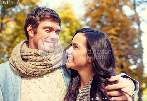 Image of smiling couple hugging in autumn park