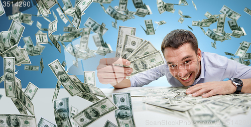 Image of happy businessman with heap of money