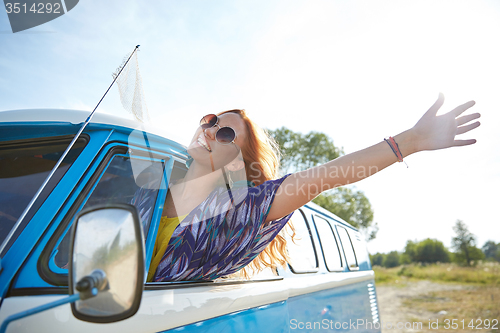 Image of smiling young hippie woman driving minivan car