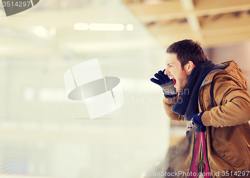 Image of young man supporting hockey game on skating rink