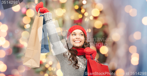 Image of happy woman in winter clothes with shopping bags