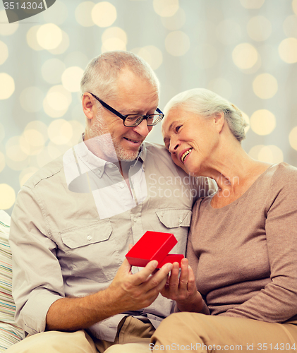 Image of happy senior couple with red gift box