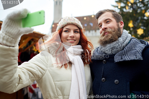 Image of couple taking selfie with smartphone in old town