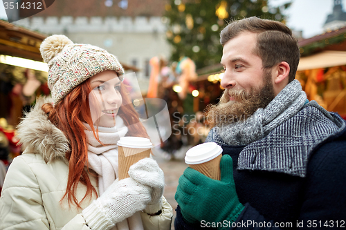 Image of happy couple drinking coffee on old town street