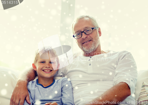 Image of smiling grandfather and grandson at home