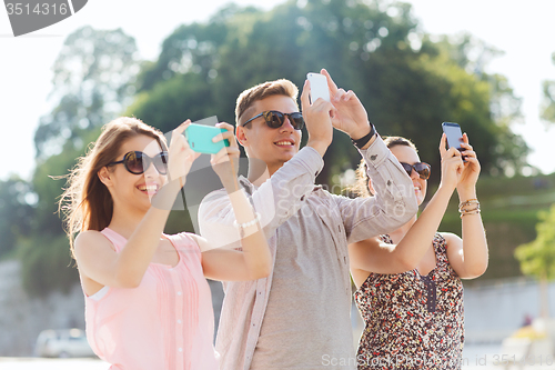 Image of smiling friends with smartphone taking picture