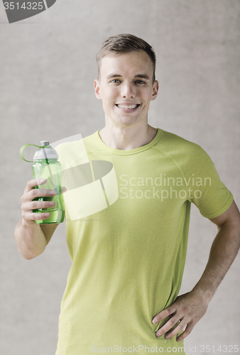 Image of smiling man with bottle of water in gym