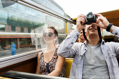 Image of smiling couple with camera traveling by tour bus
