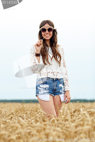 Image of smiling young hippie woman on cereal field