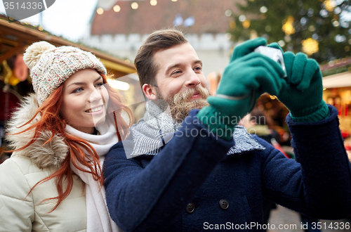 Image of couple taking selfie with smartphone in old town