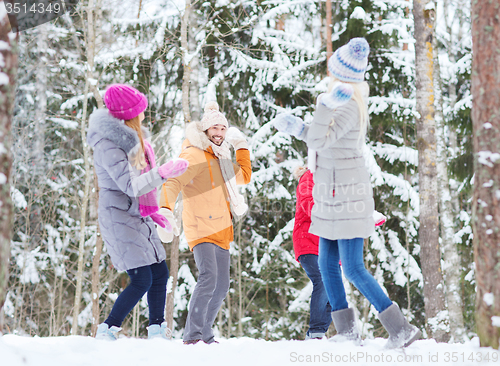 Image of group of happy friends playing snowballs in forest