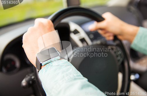 Image of close up of man with wristwatch driving car