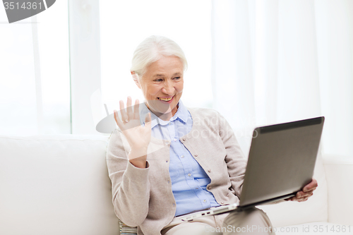 Image of senior woman with laptop having video chat at home