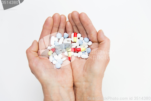 Image of close up of senior woman hands with pills