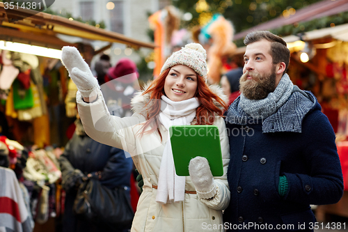 Image of happy couple walking with tablet pc in old town