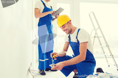 Image of builders with tablet pc and equipment indoors