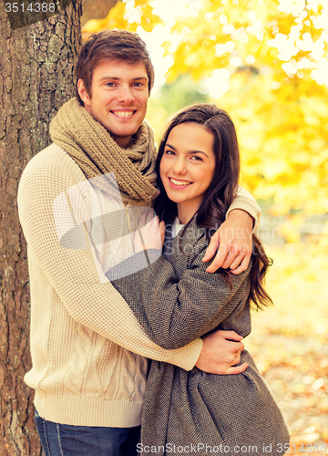 Image of smiling couple hugging in autumn park