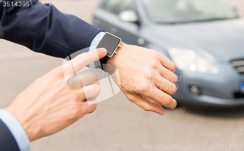 Image of close up of male hands with wristwatch and car