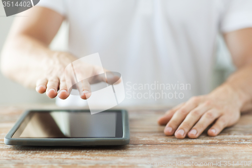 Image of close up of male hands with tablet pc on table