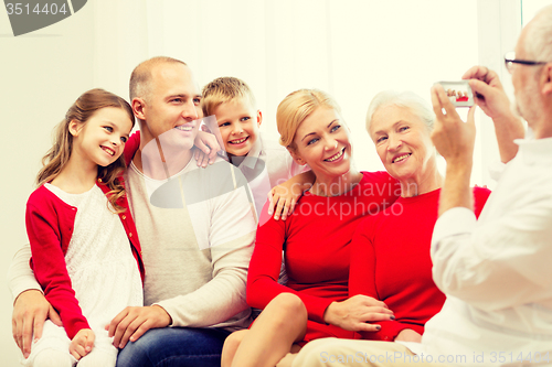 Image of smiling family with camera at home