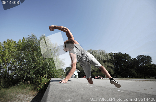 Image of sporty young man jumping in summer park