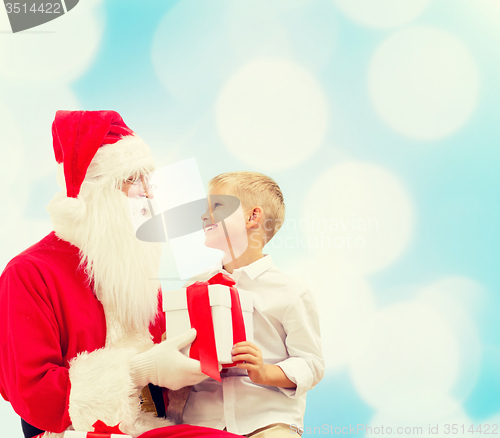 Image of smiling little boy with santa claus and gifts