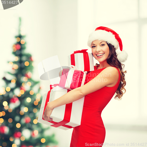 Image of woman in santa helper hat with many gift boxes