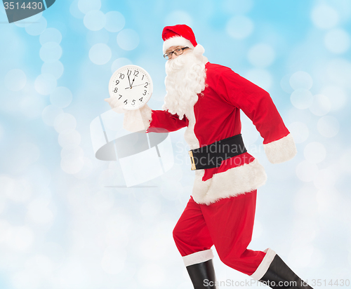 Image of man in costume of santa claus with clock