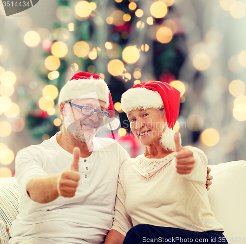 Image of happy senior couple in santa helper hats