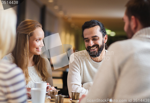 Image of happy friends meeting and drinking tea or coffee