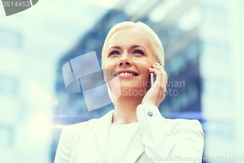 Image of smiling businesswoman with smartphone outdoors