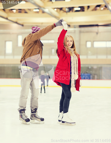 Image of happy couple holding hands on skating rink