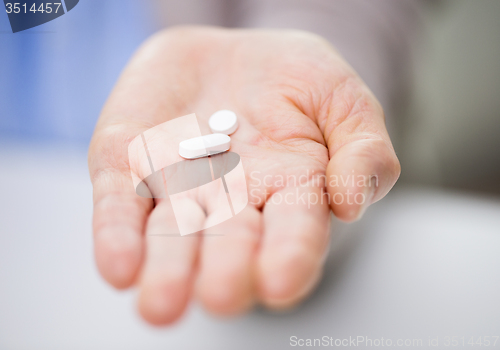 Image of close up of senior woman hand with pills