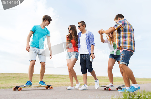 Image of happy teenage friends with longboards outdoors