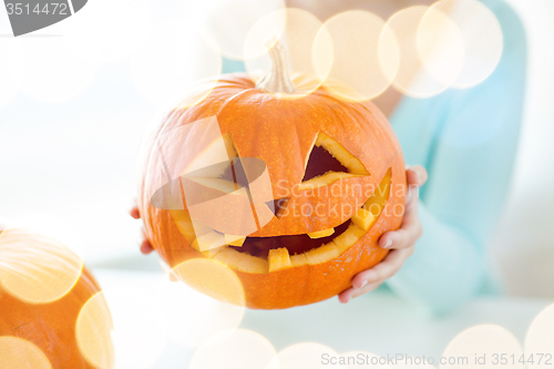 Image of close up of woman with pumpkins at home