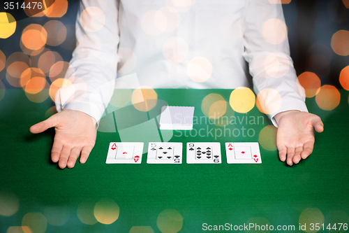 Image of holdem dealer with playing cards over lights