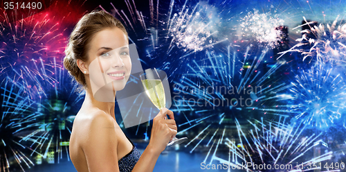 Image of happy woman drinking champagne over firework