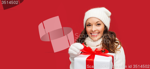 Image of smiling woman in white clothes with gift box