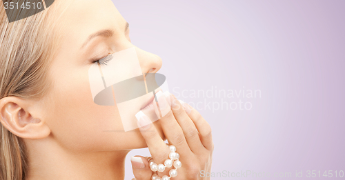 Image of beautiful woman with sea pearls beads over violet