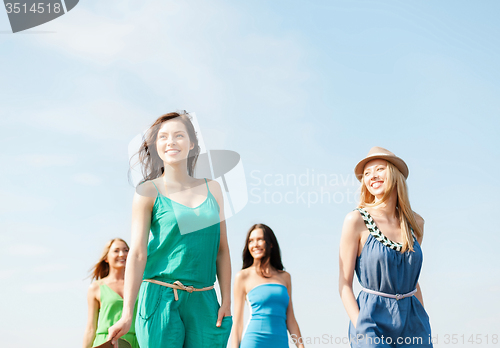 Image of smiling girls walking on the beach