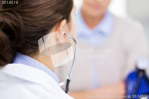 Image of doctor with tonometer and senior woman at hospital