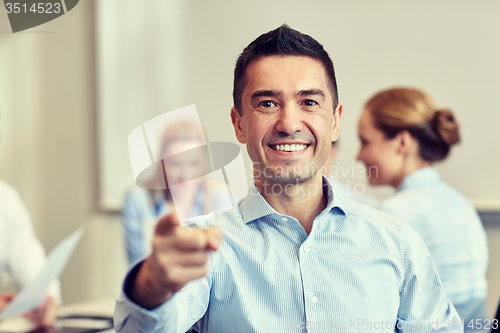 Image of group of smiling businesspeople meeting in office